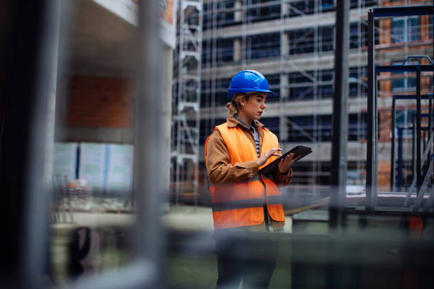 Cheffe de chantier remplissant un rapport sur tablette